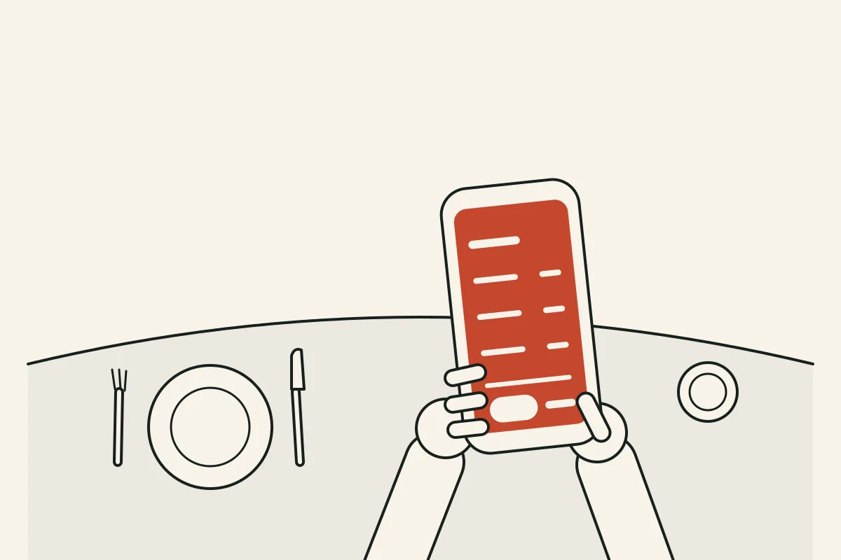 Manos sosteniendo un celular con un presupuesto abierto, sobre una mesa de comedor